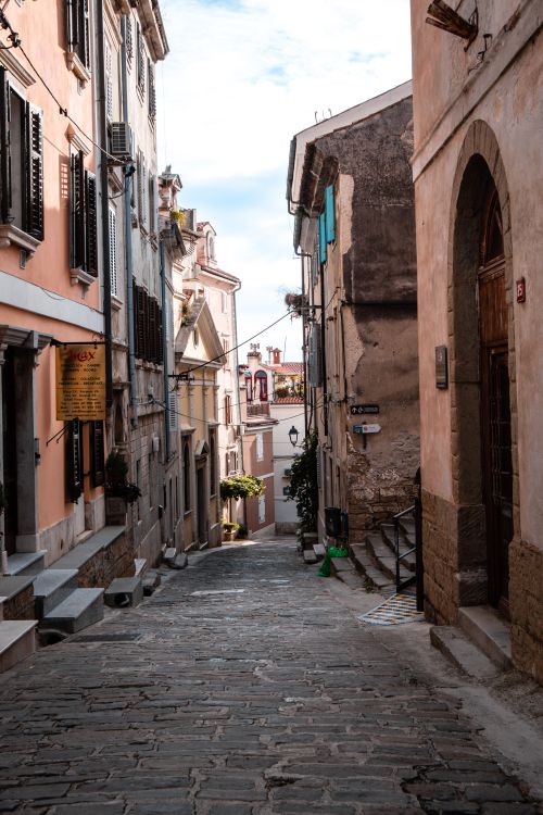 Free Discover this quaint cobblestone alleyway lined with vintage buildings in a charming historic town. Stock Photo