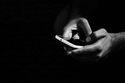Free Grey Scale Photo of Person Holding Smartphone Stock Photo