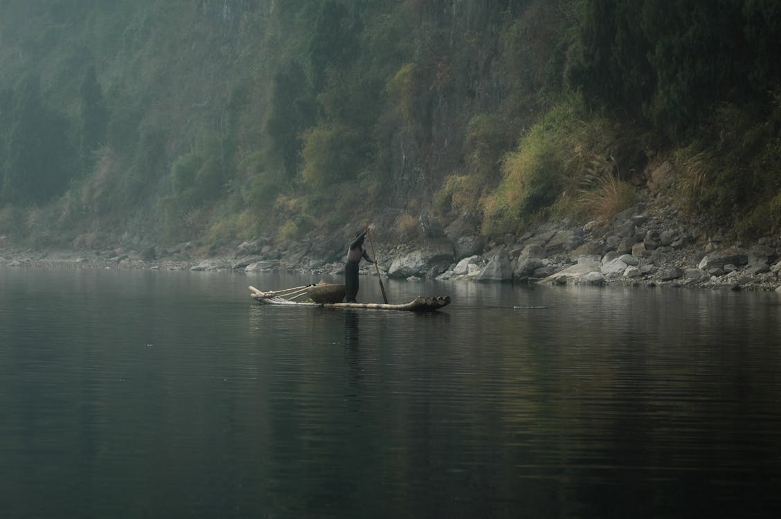 Person Riding on Canoe on River