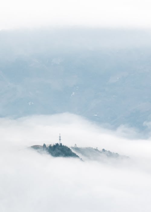 Peak of a Mountain Above Dense Clouds and Fog 