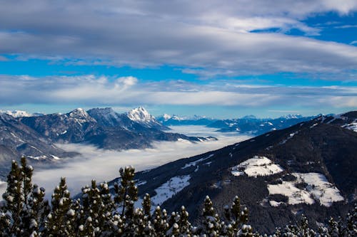 Snow Capped Mountains Under White Clouds and Blue Sky