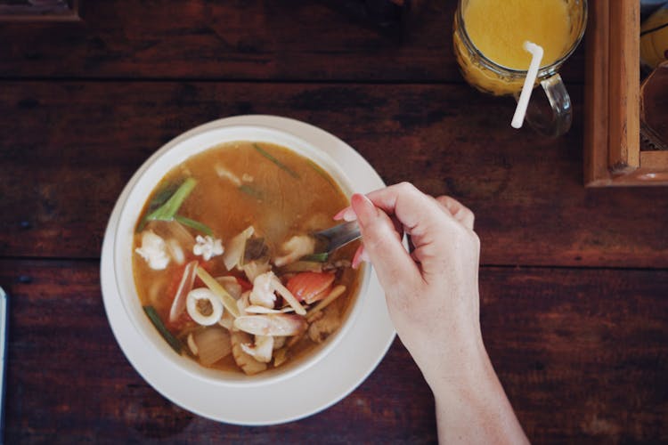 A Person Eating A Soup