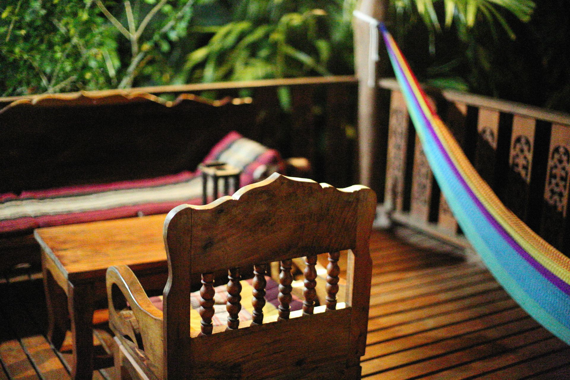 Inviting tropical outdoor patio featuring wooden furniture and vibrant hammock for a relaxing ambiance.
