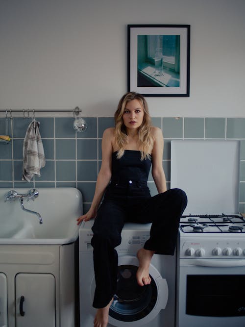 Free Woman Sitting on Washing Machine Stock Photo