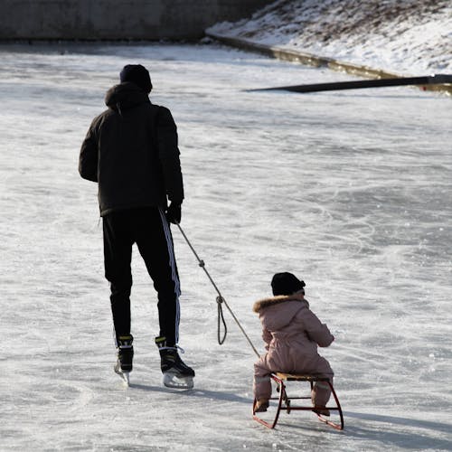 Man Pulling Baby on a Sled 