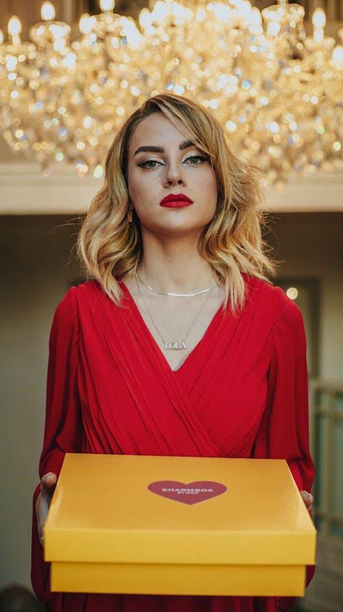 Woman in Red Dress Holding a Yellow Box