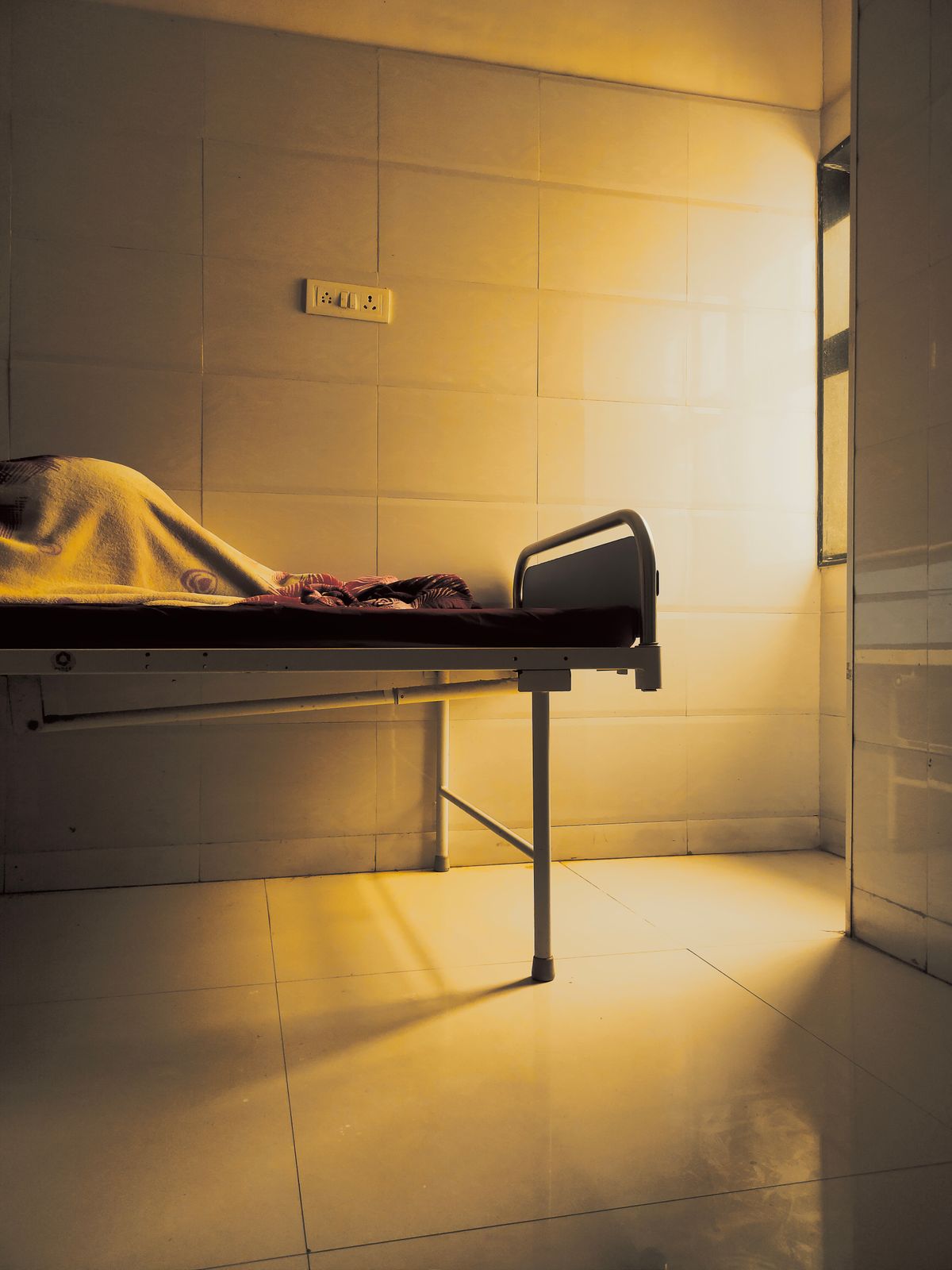 Empty hospital patient bed in an Indian ward after discharge