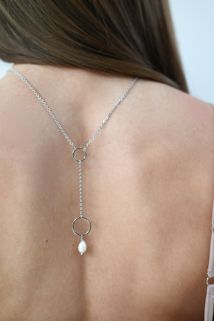 Woman With A Sliver Necklace On Her Back 