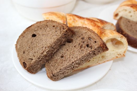 An appetizing close-up of freshly baked artisan bread slices on a white plate.
