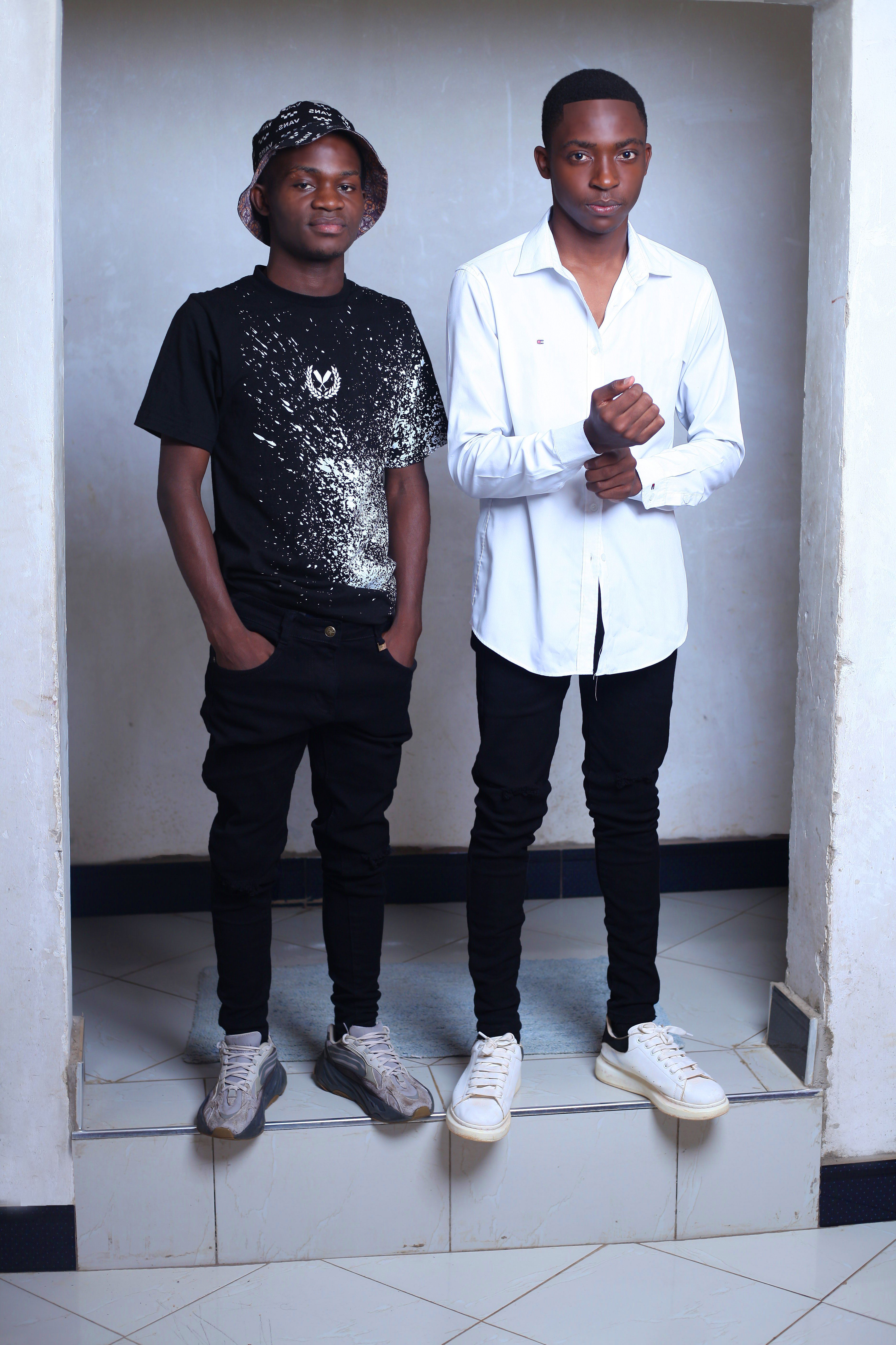 Portrait of two young men posing in casual clothing indoors, featuring modern urban fashion.