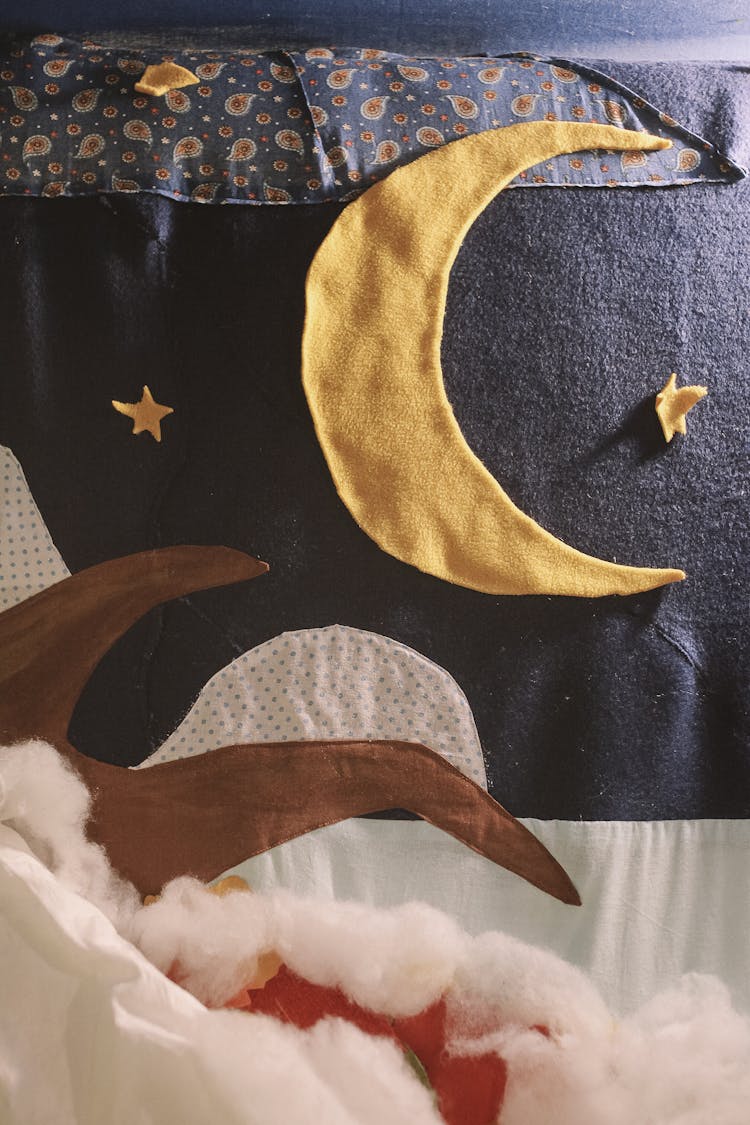 A Quilt With Fabric Moon And Stars Cutouts