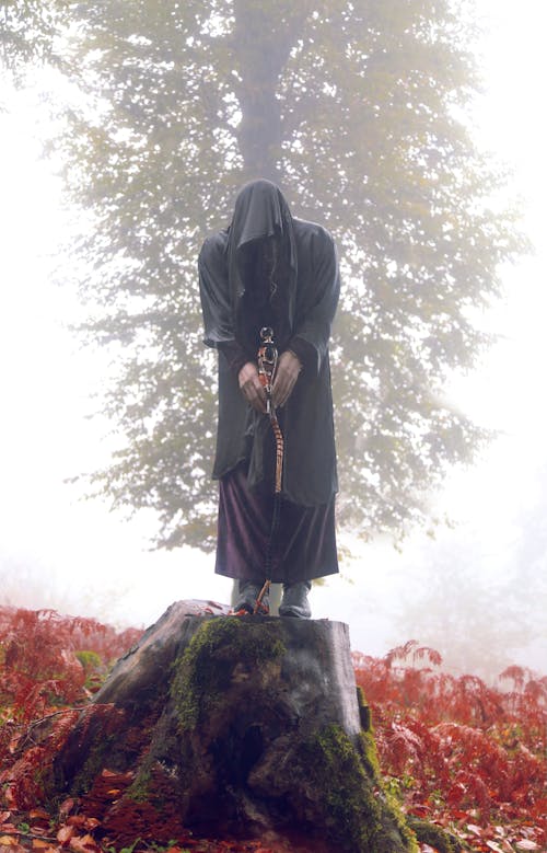 Free Woman in Black Robe Standing on Rock Stock Photo
