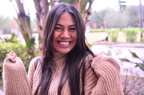 Smiling Woman in Brown Knitted Sweater