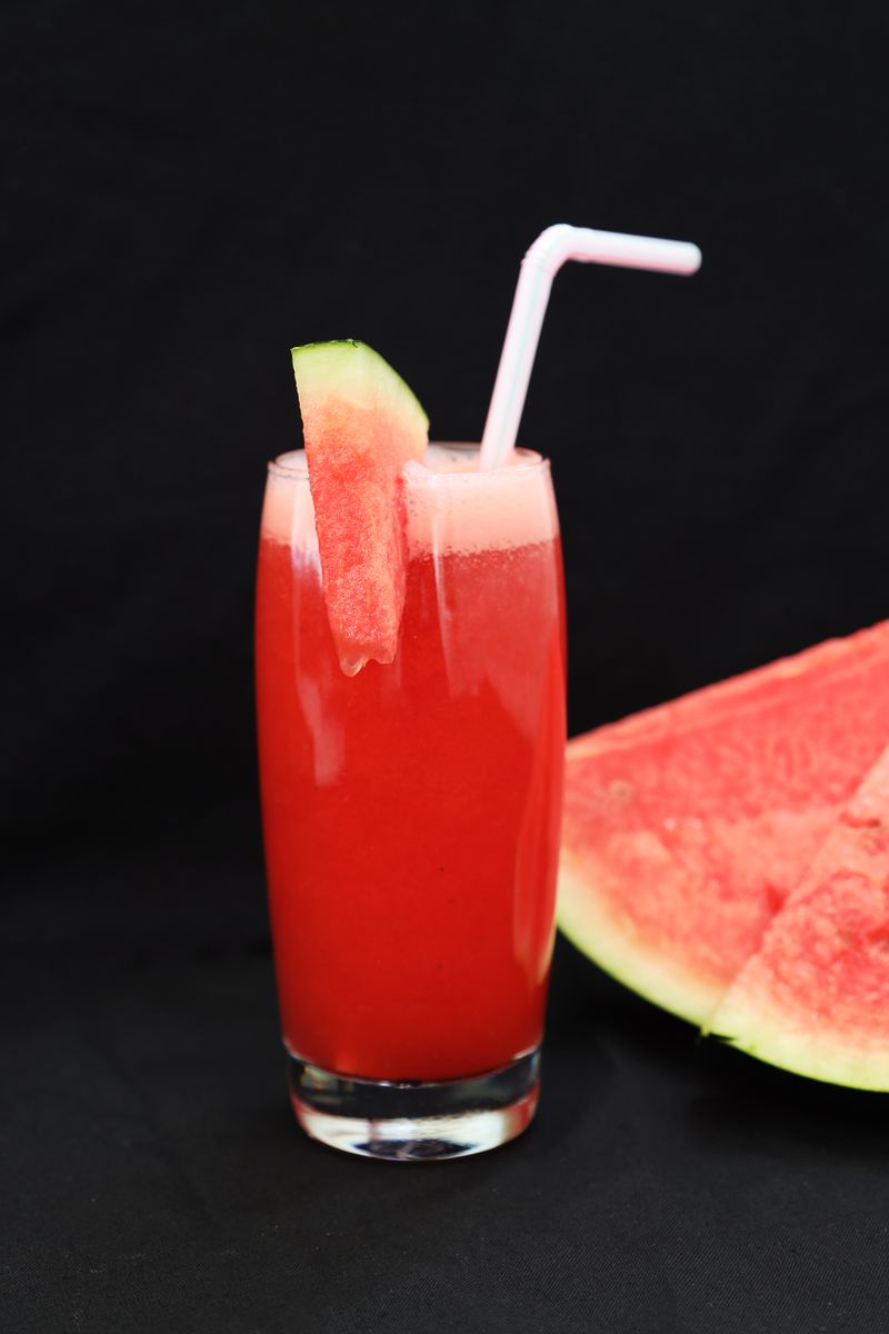 Segelas jus tembikai segar merah dengan sedotan