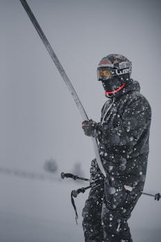 A skier in black attire navigating the snowy slopes of Gulmarg during heavy snowfall.