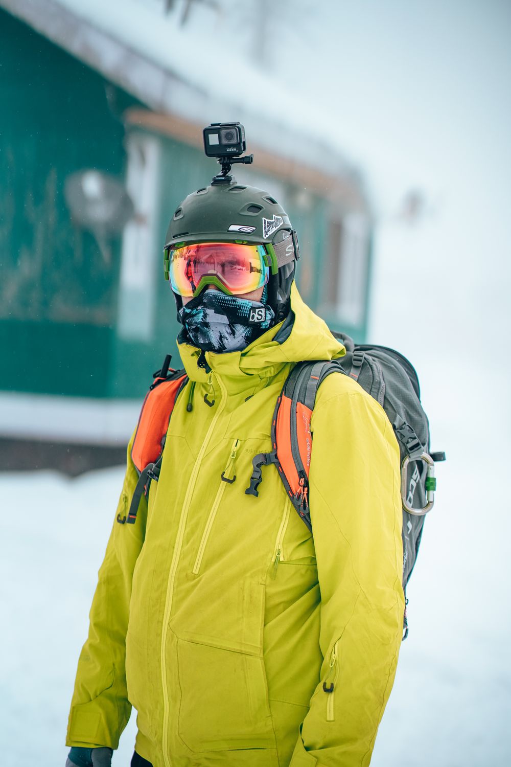 Skier in bright gear with a helmet camera in a snowy mountain landscape Skier in bright gear with a helmet camera in a snowy mountain landscape