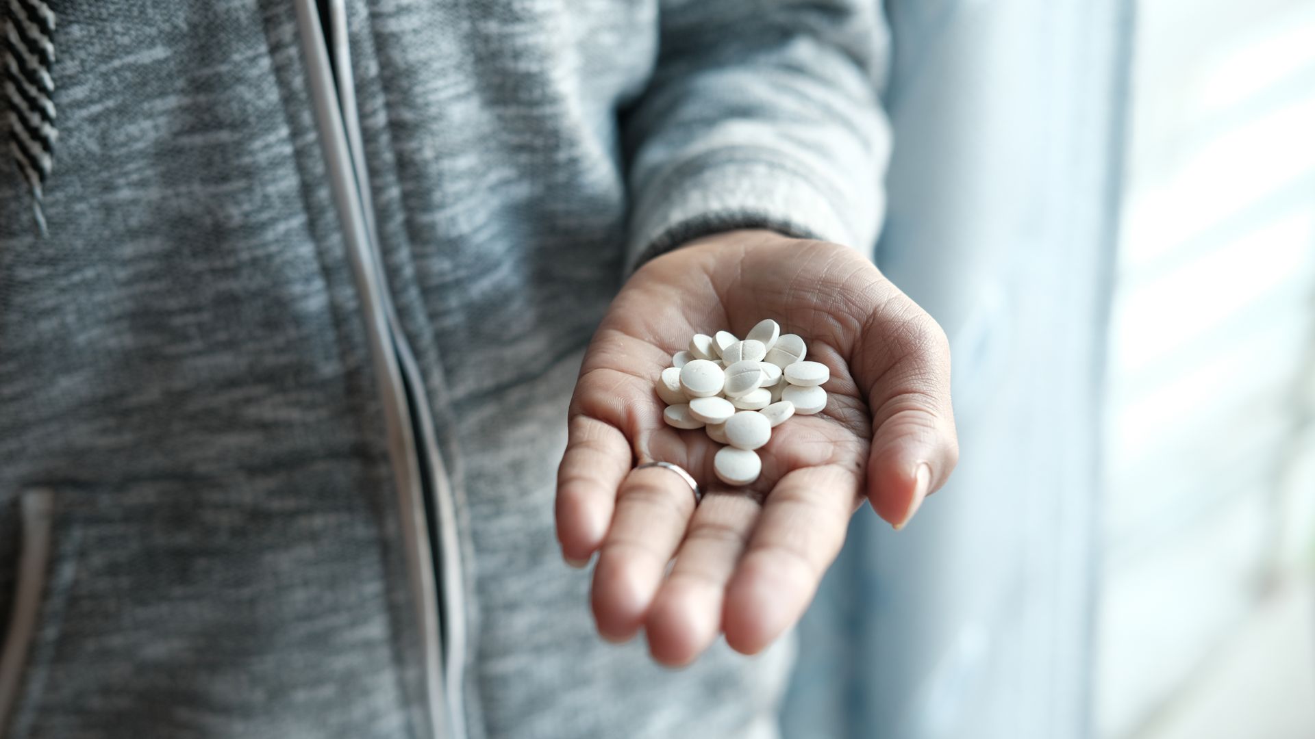 Modvigil 200 Dosage: Unlocking the Ideal Amount A person holding a handful of white pills, depicting a focus on medication and healthcare.