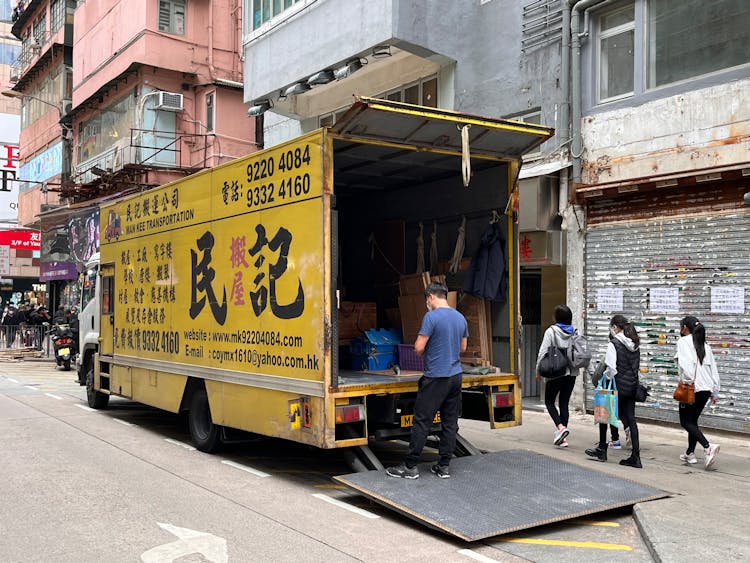 Men Unloading Truck On City Street