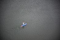 Person Riding Blue and Red Paddleboard on Water