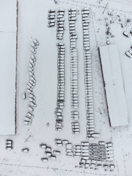 Aerial shot of a snowy parking lot with vehicles in Murmansk, Russia during winter.