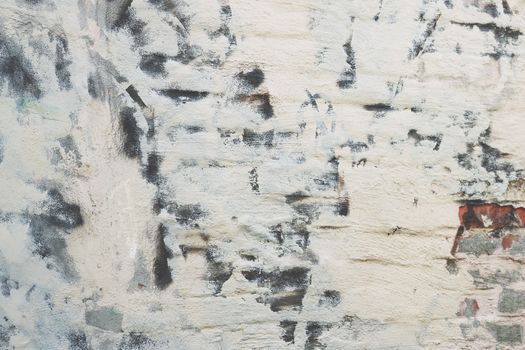 Close-up of textured brick wall with abstract graffiti, showing weathered surface.
