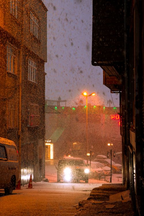 Free A car navigates through a snowy Istanbul street at night, illuminated by street lamps. Stock Photo