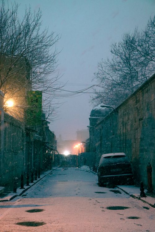 Free A serene snowy street in Istanbul at dusk, capturing the quiet beauty of winter. Stock Photo