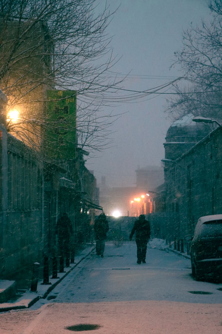 People Walking On A Street At Night