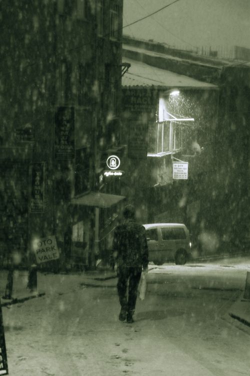 Free A person walks through an alley in Istanbul during heavy snowfall, creating a serene winter scene. Stock Photo