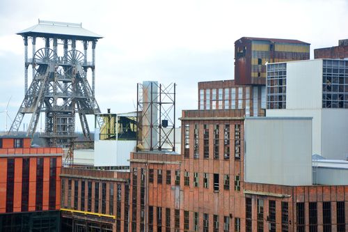 Free A detailed view of an old industrial complex with distinctive steel architecture and brickwork. Stock Photo
