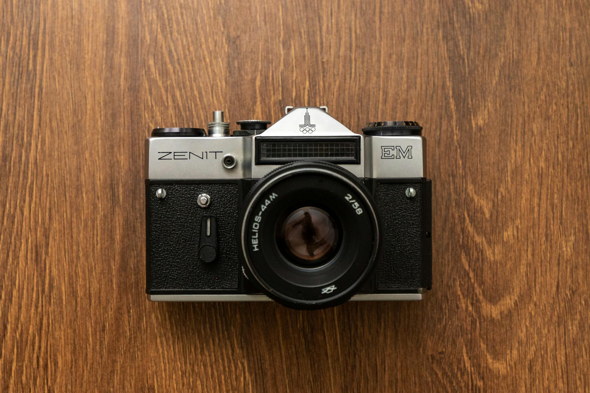 Top view of a classic Zenit EM analog camera on a wooden surface, showcasing vintage photography equipment.