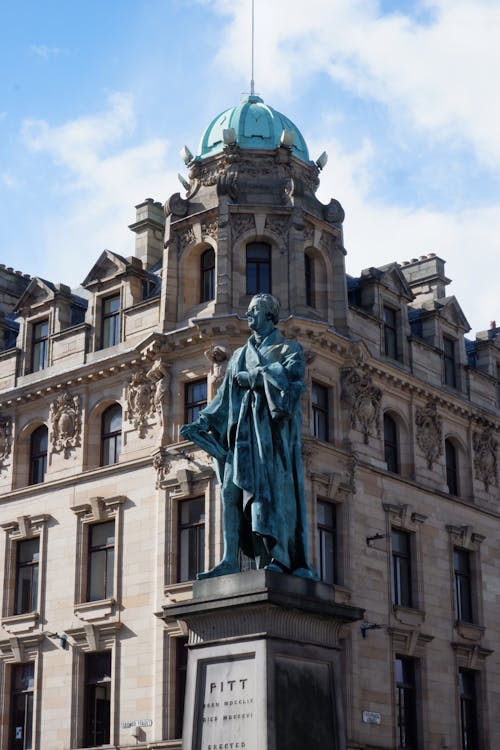 Statue of Man in Front of a Baroque Design Building