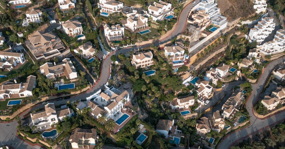 Aerial view showcasing a picturesque suburban area in Spain with elegant homes and pools.