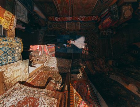 Stunning aerial shot of a newlywed couple on vibrant carpets in Göreme, Turkey.