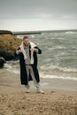Young Short-hair Man in Sportswear Wearing Long Warm Coat and Posing at Seashore