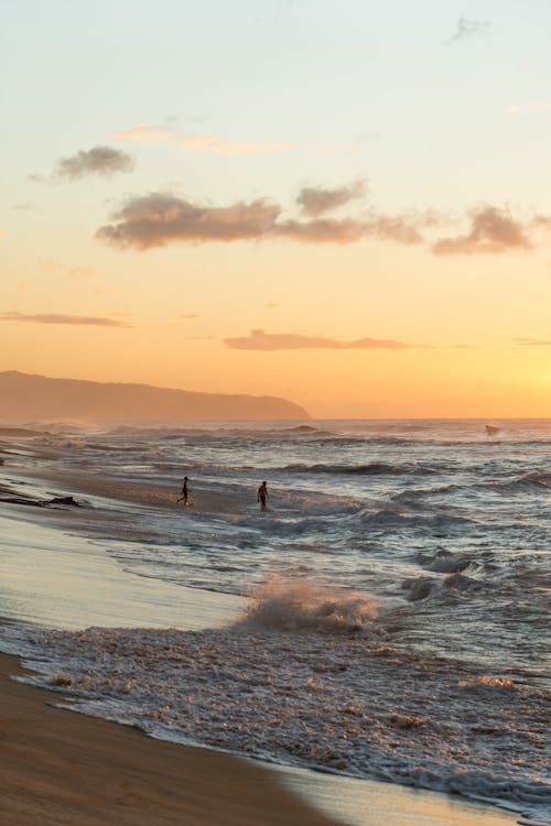 Free Waves Crashing on a Beach at Sunset Stock Photo