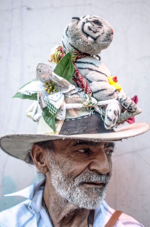 Free Senior man wearing an imaginative hat adorned with stuffed animals and decorations, showcasing creativity and individuality. Stock Photo