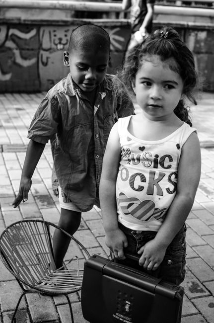 Fotomural Dos niños juegan al aire libre con juguetes, mostrando la diversión y la creatividad de la infancia.