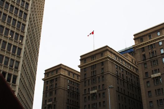 Experience a low angle urban perspective of downtown Calgary's iconic architecture under a neutral sky.
