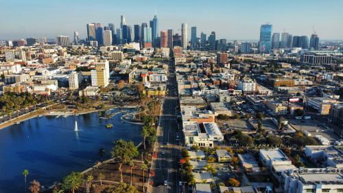 Free Stunning aerial shot of downtown Los Angeles with skyscrapers, city streets, and a serene park. Stock Photo