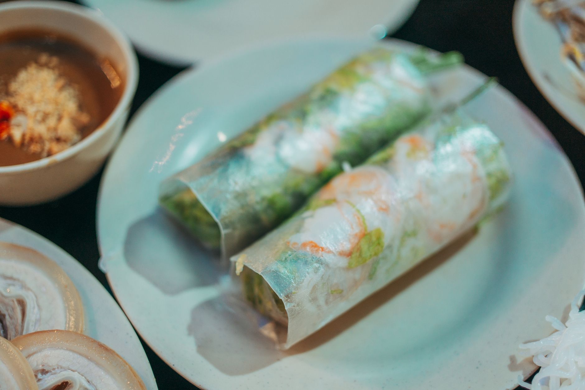 Appetizing Vietnamese spring rolls served with dipping sauce on a white plate, perfect for a healthy meal.