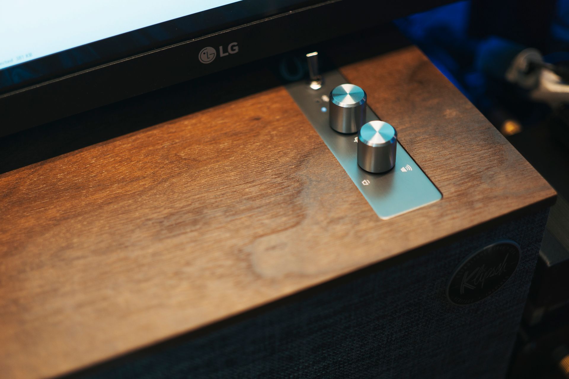 Close-up of a modern audio control panel with knobs on a wooden surface, ideal for sound setups.