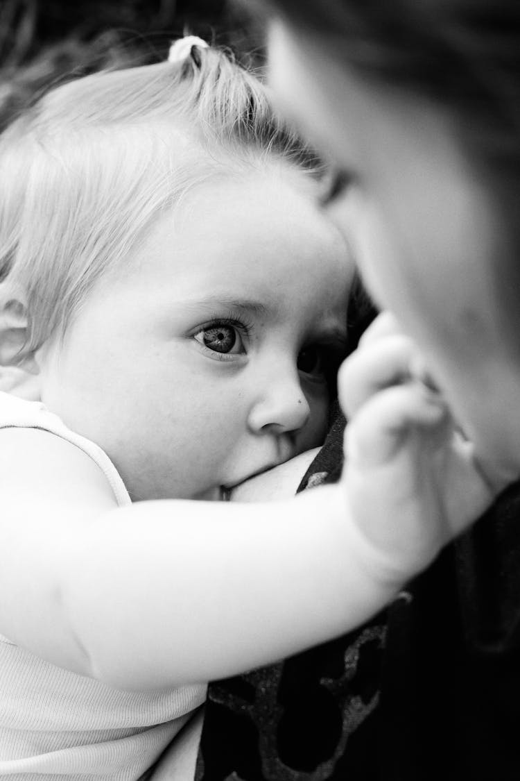 Black And White Photo Of Woman Breastfeeding Her Baby 