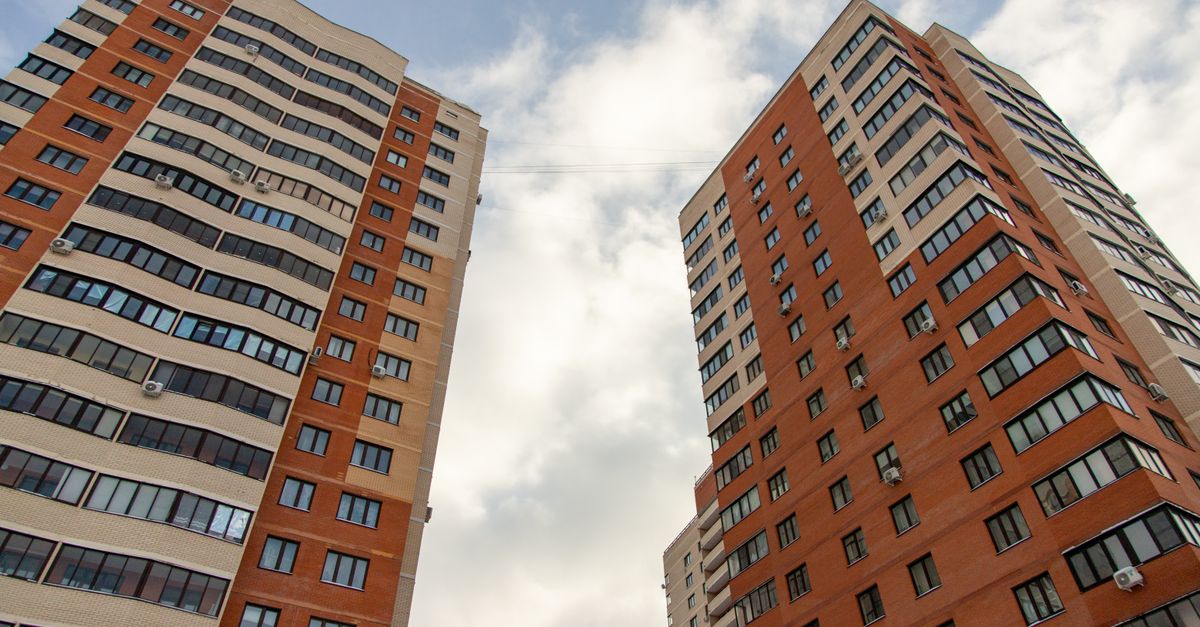 Low-angle shot of modern high-rise buildings with a cloudy sky backdrop, capturing urban architecture.