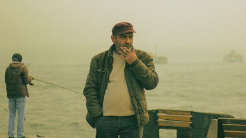 Free Man Looking Serious while Smoking a Cigarette Stock Photo