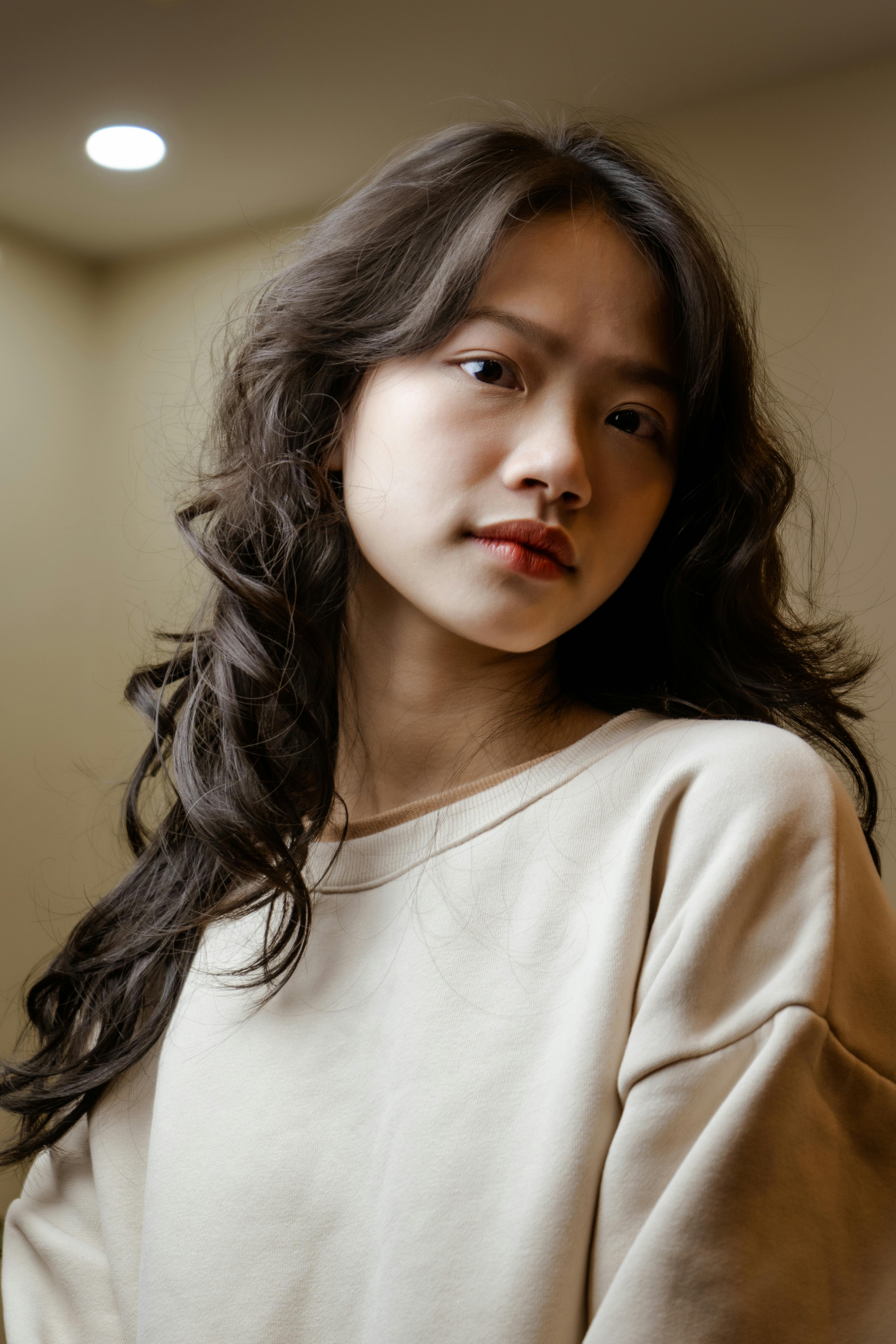 Captivating portrait of a woman with long hair indoors, exuding elegance and style.