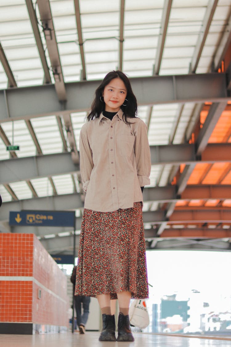 A Woman In Brown Button Up Long Sleeve Shirt And Brown Floral Skirt