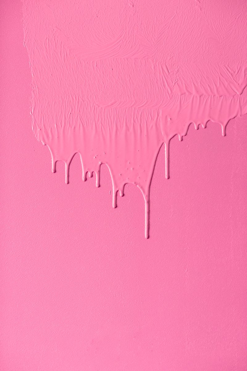 Pink paint dripping down a freshly coated wall