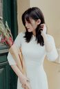 Woman in Form-fitting White Dress Holding Bouquet of Flowers