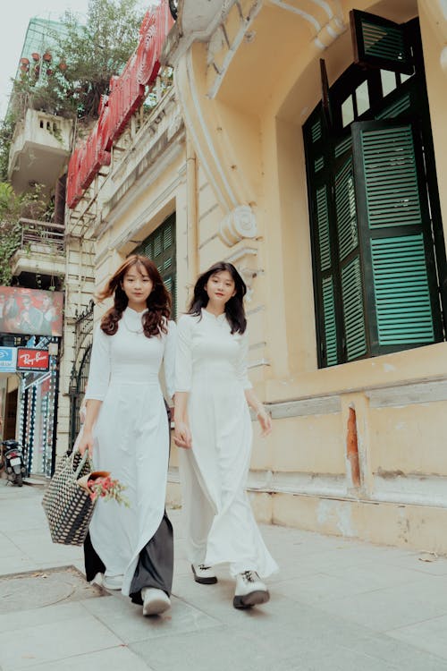 Women in White Dresses Walking on the Street